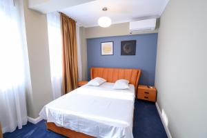 ein Schlafzimmer mit einem Bett und einer blauen Wand in der Unterkunft Aquarium Residence Penthouse 7 in Mamaia Nord – Năvodari