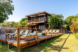 a house on a wooden deck with chairs on it at Sunset Lodge in St Lucia