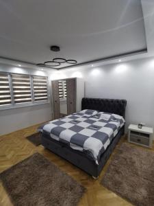 1 dormitorio con 1 cama grande y 2 alfombras en Apartman Cipi2, en Sombor