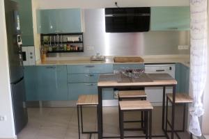 a kitchen with blue cabinets and a table with stools at Appartement d'une chambre avec balcon amenage et wifi a Le Gosier a 1 km de la plage in Le Gosier