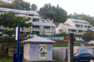 una pequeña casa con graffiti en un estacionamiento en Appartement d'une chambre avec balcon amenage et wifi a Le Gosier a 1 km de la plage en Le Gosier
