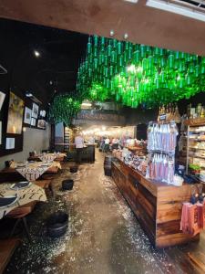 un restaurant avec des bouteilles vertes suspendues au plafond dans l'établissement Rivero Aviles Home, à Avilés