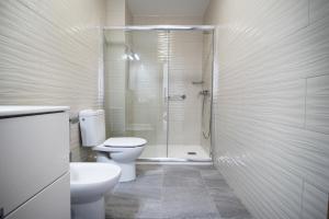 a white bathroom with a toilet and a shower at Casa Playa Chica in Gran Tarajal