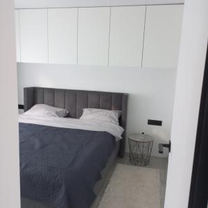 a bedroom with a large bed with white walls at New and comfortable apartments in Uzhhorod