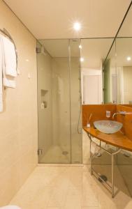 uma casa de banho com uma cabina de duche em vidro e um lavatório. em Sunny Lounge Apartment no Vale do Lobo