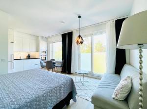 een slaapkamer met een bed en een bank en een keuken bij Cozy studio, easy access to Helsinki and near shopping center in Helsinki