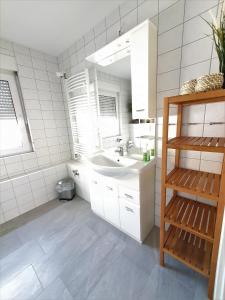 a white bathroom with a sink and a mirror at Ferienwohnungen Wassergrundstück Malchow in Malchow