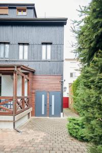 dom z niebieskimi drzwiami garażowymi na podjeździe z cegły w obiekcie L'Alsacien Artiste - Art - Moderne - Wifi - Netflix w Miluzie
