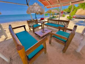 - un groupe de chaises et de tables sur la plage dans l'établissement Tintipan Ashram Hostel & Glamping, à Tintipan Island