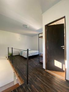 1 dormitorio con 1 cama y puerta que conduce a una habitación en Complejo Las Flores - Lugar campestre a 5 minutos de Termas Chajarí en Chajarí