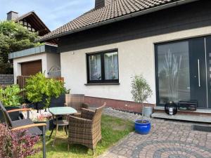 a patio with a table and chairs in front of a house at FeWoWe Ferienwohnung Wenden in Wenden
