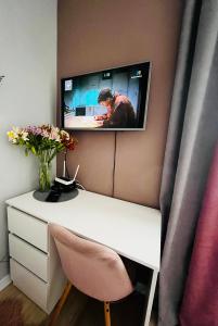 un escritorio blanco con TV en la pared en Iren Smart Apartment en Leópolis