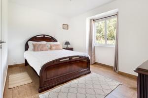 ein Schlafzimmer mit einem großen Bett und einem Fenster in der Unterkunft ALTIDO Quaint house with Patio in Sintra