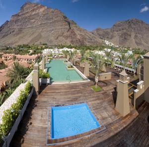 a resort with a pool and mountains in the background at Hotel Playa Calera in Valle Gran Rey