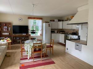 uma cozinha e sala de jantar com mesa e cadeiras em Uppleva att bo på en gammal gård em Kumlinge