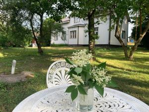 uma mesa com um vaso de flores sobre uma mesa em Uppleva att bo på en gammal gård em Kumlinge