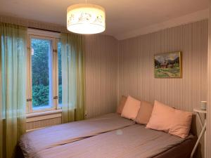 um quarto com uma cama grande e uma janela em Uppleva att bo på en gammal gård em Kumlinge