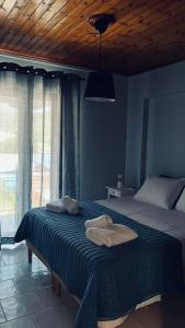 a blue bedroom with a bed with towels on it at Thelxis Room in Nydri