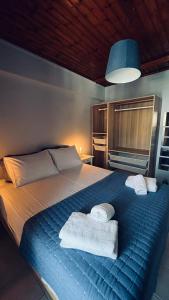 a bedroom with a blue bed with towels on it at Thelxis Room in Nydri