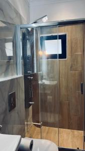 a shower with a glass door in a bathroom at Thelxis Room in Nydri