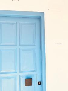 a blue door in front of a white wall at Thelxis Room in Nydri