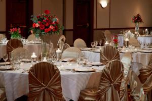 una sala de banquetes con mesas blancas, sillas y flores en Columbus Airport Marriott en Columbus