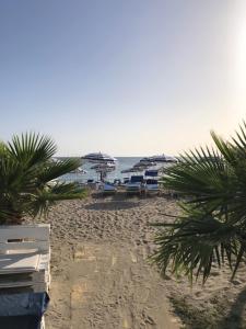 una playa de arena con sombrillas y el océano en Stella Marina en Marsala