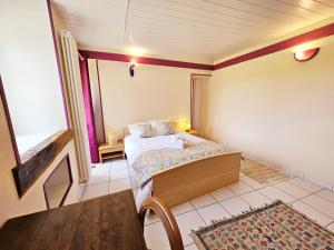 ein kleines Schlafzimmer mit einem Bett und einem Tisch in der Unterkunft Gîte Le creux du loup in La Couronne