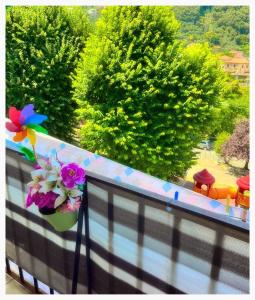un balcone con un vaso di fiori e fiori su una recinzione di Dodo House La Spezia a La Spezia