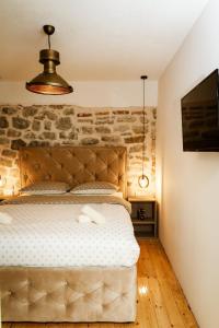 een slaapkamer met een bed met een stenen muur bij Apartment Nada Smodlaka in Tivat