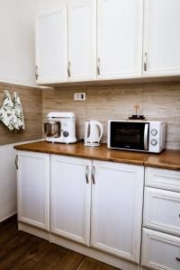 een keuken met witte kasten en een magnetron op een aanrecht bij Apartment Nada Smodlaka in Tivat