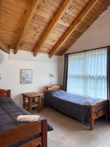 - une chambre avec 2 lits et une fenêtre dans l'établissement Portal del Manzano, à Villa La Angostura