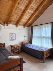 a bedroom with two beds and a window at Portal del Manzano in Villa La Angostura