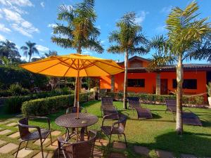 a table and chairs with an umbrella in a yard at CHÁCARA BARBOSA II in Socorro