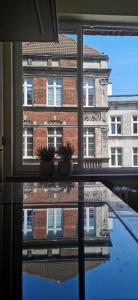 une fenêtre reflétant un bâtiment dans l'eau dans l'établissement Rudy Kot, à Gdańsk