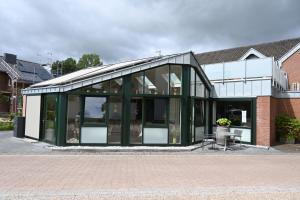 a glass extension to a building with a table at Hotel Restaurant Zum Schwan in Goch