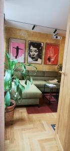 ein Wohnzimmer mit einem Sofa und einer Pflanze in der Unterkunft Rudy Kot in Danzig