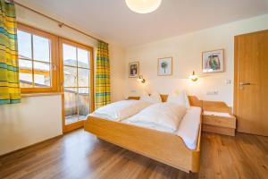 a bedroom with a bed with white pillows and a window at Pension Braunhofer in Schladming