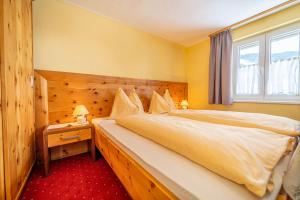 - une chambre avec un grand lit et une fenêtre dans l'établissement Pension Braunhofer, à Schladming