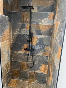 uma casa de banho com um chuveiro e uma parede de pedra em Maison avec jacuzzi em Orange