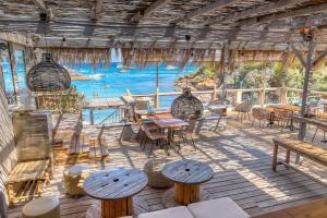 a patio with tables and chairs and a view of the water at Akwabay - Les Villas du Cap in Le Lavandou