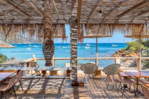 a restaurant with tables and chairs and a view of the ocean at Akwabay - Les Villas du Cap in Le Lavandou