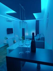 dwa kieliszki do wina i butelkę na stole w salonie w obiekcie Apartman "Ina" Banja Luka w mieście Banja Luka