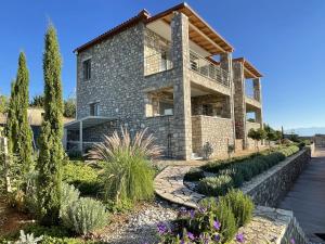 a stone house with a garden in front of it at Stonevillas and Seaview Garden Marion in Agnándion