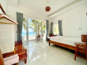 a bedroom with a bed and a view of the ocean at Lucky Spot Beach Bungalow in Song Cau