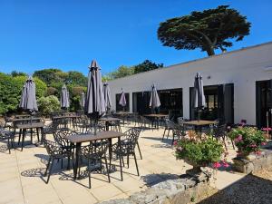 a patio with tables and chairs with umbrellas at South Lawn Hotel in Lymington