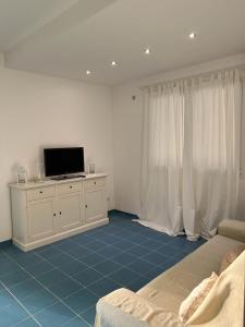 sala de estar con sofá, TV y cortinas en Archiammare Sea, en Reitani