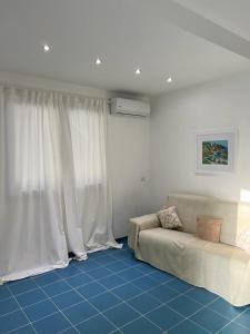 sala de estar con sofá y cortinas blancas en Archiammare Sea, en Reitani
