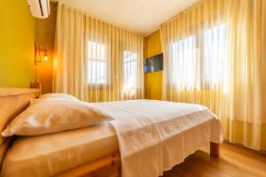 een slaapkamer met een bed met gele muren en ramen bij Mavi Deniz Otel in Kemer