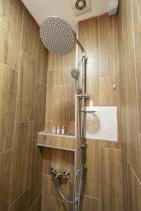 a shower in a bathroom with wooden walls at Hotel M Star Novi Pazar in Novi Pazar